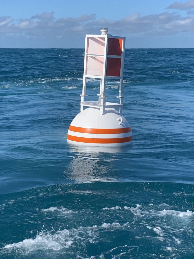 58/14 steel smart buoy, a 58 inch white steel channel marker buoy with orange and white dayboard tower, built-in radar reflector and light, on station offshore