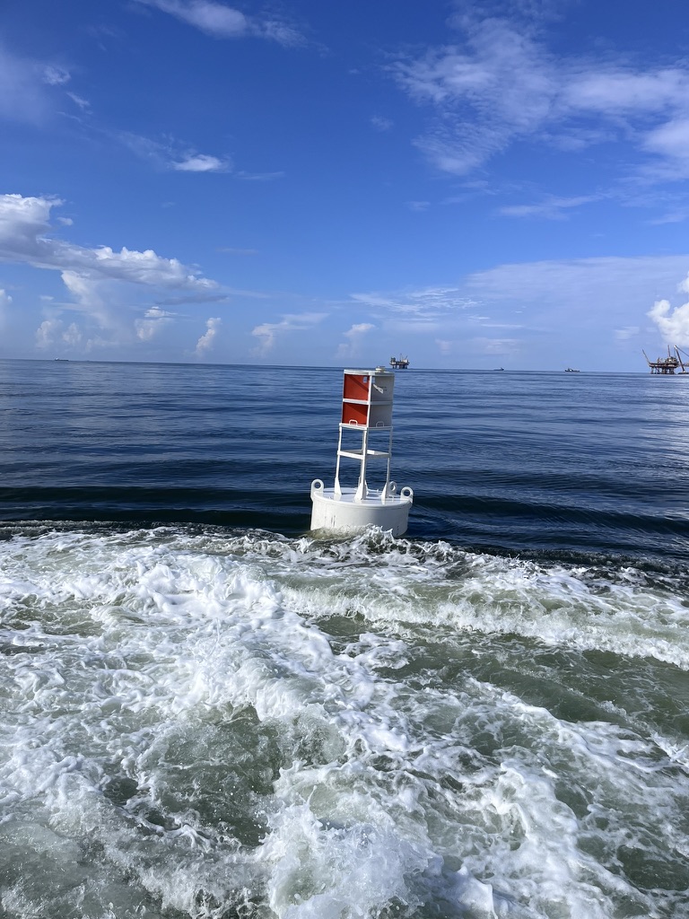 BL 620 smart buoy (620 buoy), a white steel navigation buoy with welded tower and built-in radar reflector, on station offshore in the Gulf, built by Wet Tech Energy in Maurice, Louisiana