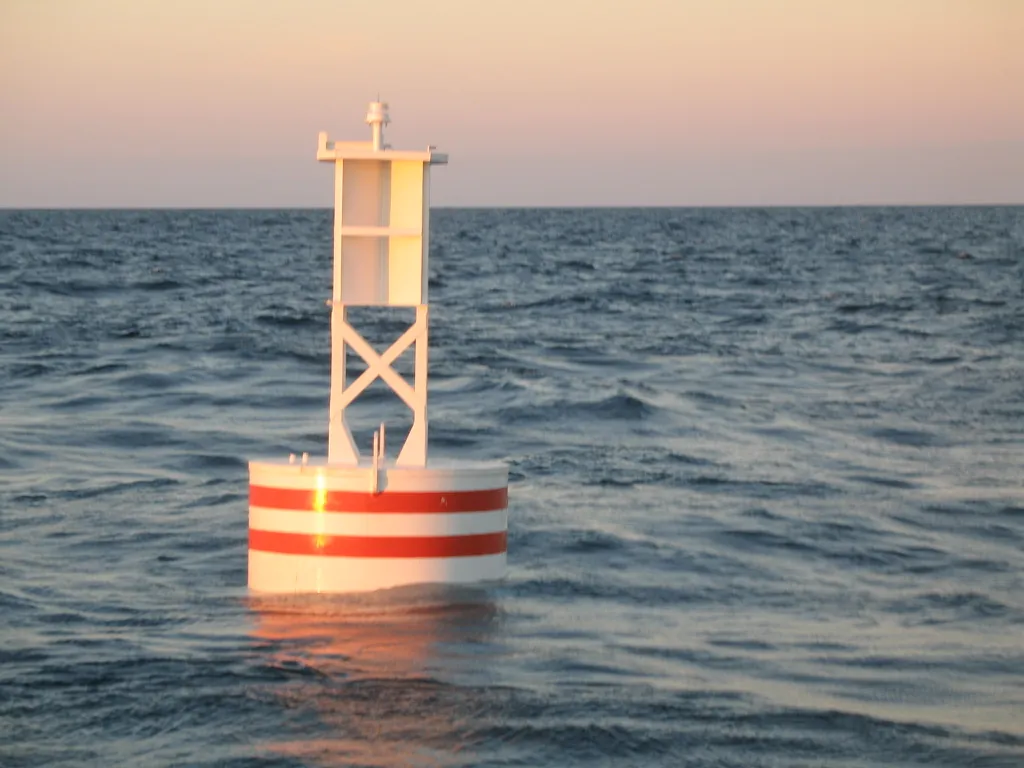 BL 620 smart buoy, a white 620 steel buoy with red bands and LED lantern on its welded tower, on station offshore