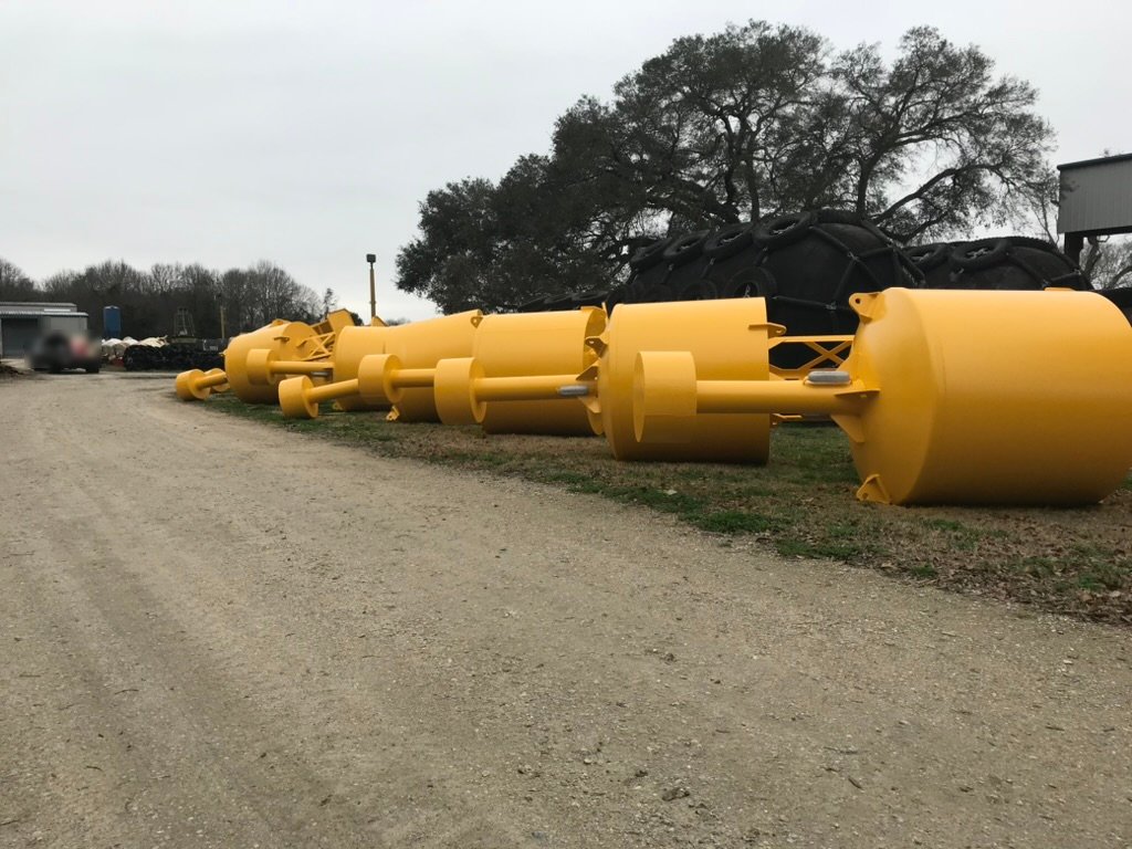 Row of yellow-painted BL 620 steel buoys in the Wet Tech yard, ready to ship internationally